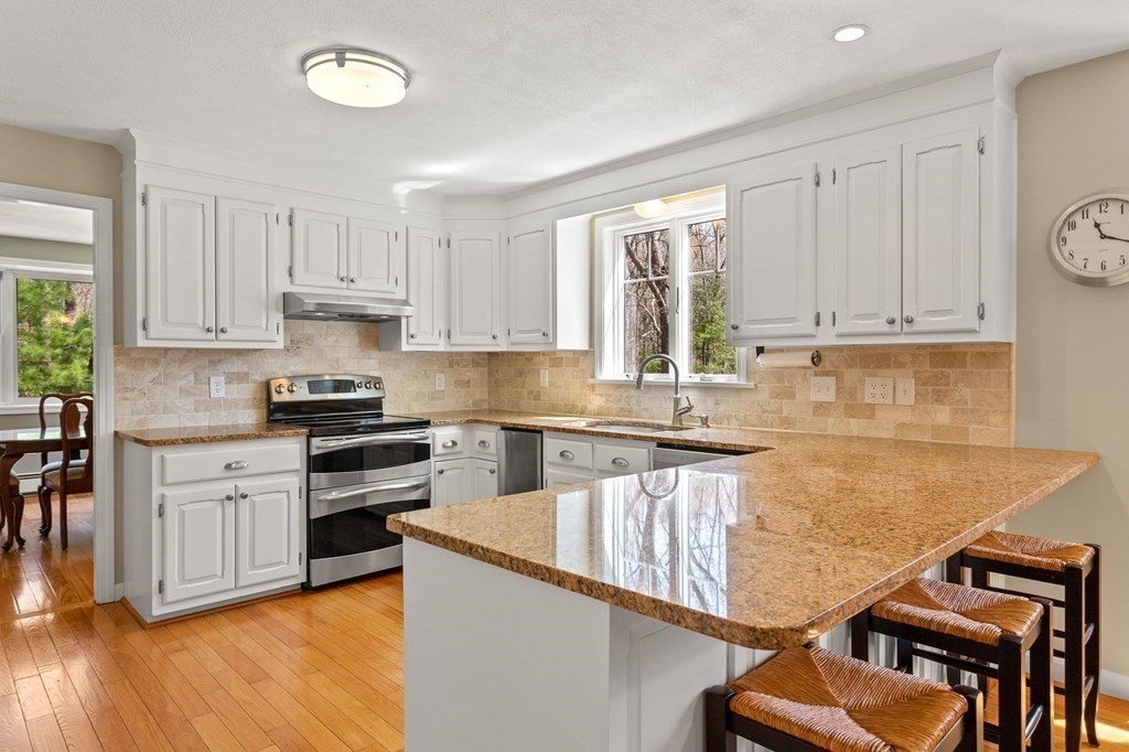 136 Leslie Road Rowley, MA 01969 - Photo 7 of 28 a kitchen with granite countertop a stove top oven a sink a counter space and cabinets