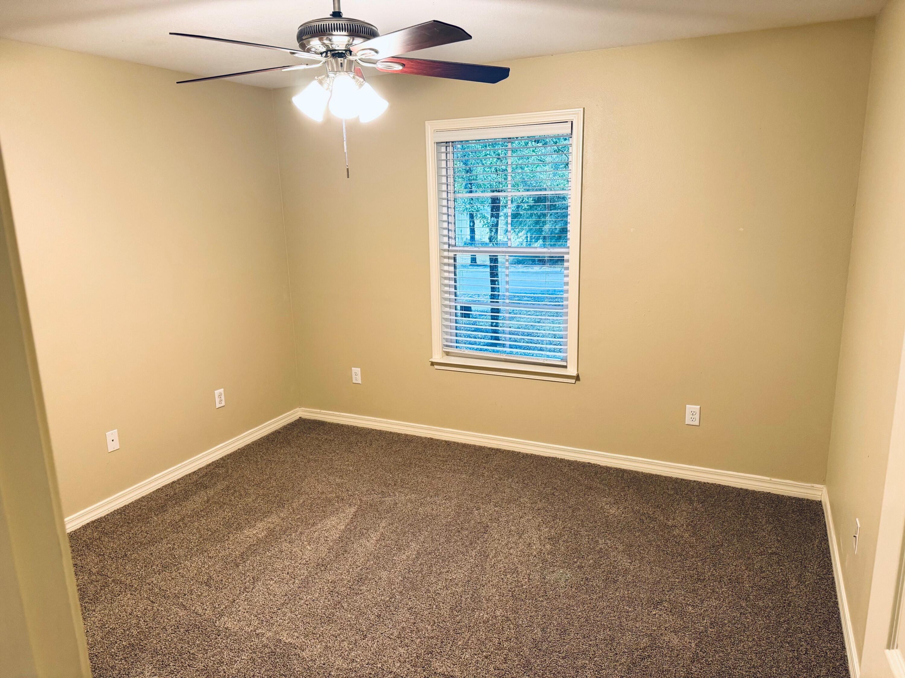 594 Hunters Ridge Road DeFuniak Springs, FL 32433 - Photo 12 of 17 an empty room with a chandelier fan and windows