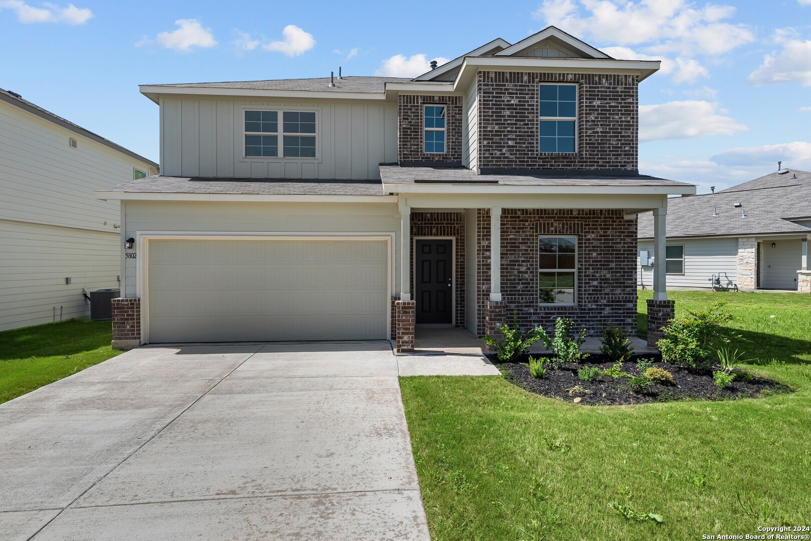 a front view of a house with a yard and garage