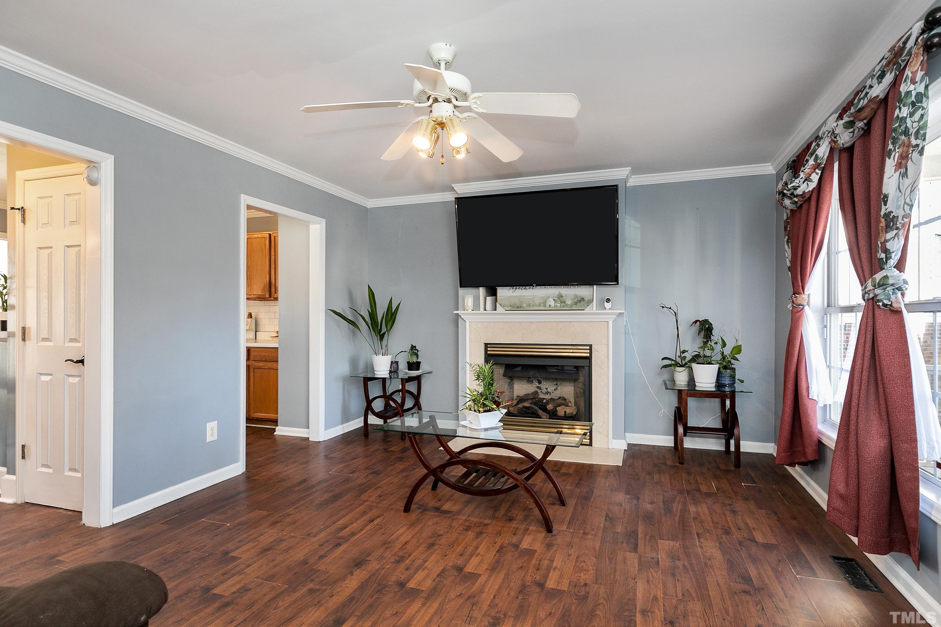 4416 Windstorm Way Raleigh, NC 27616 - Photo 5 of 31 a living room with furniture a fireplace and a flat screen tv
