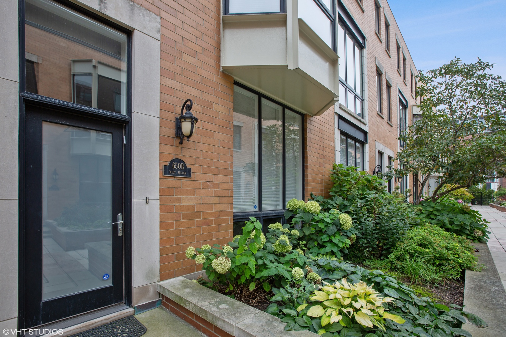 a view of a brick house with a flower plants
