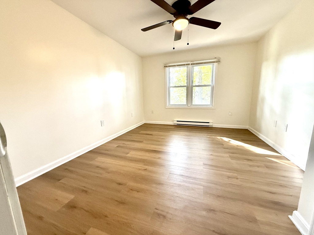 9 Olga Avenue, Unit 9 Worcester, MA 01605 - Photo 14 of 24 an empty room with wooden floor fan and windows