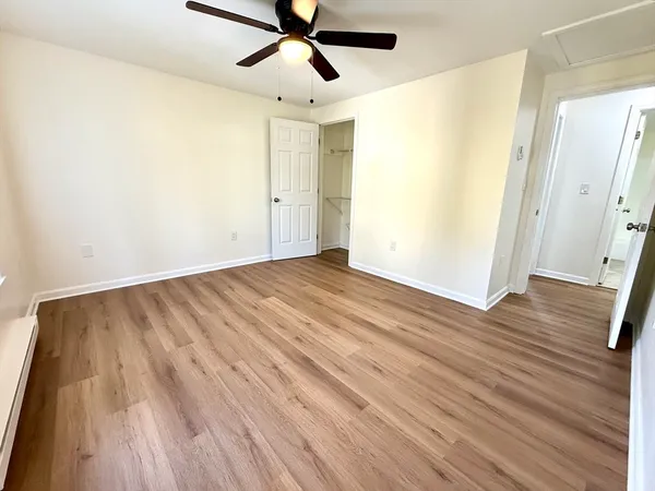 an empty room with wooden floor and windows