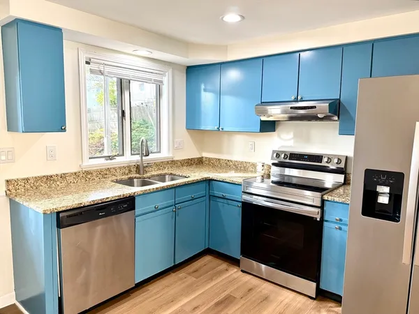 a kitchen with granite countertop wooden cabinets and a stove top oven