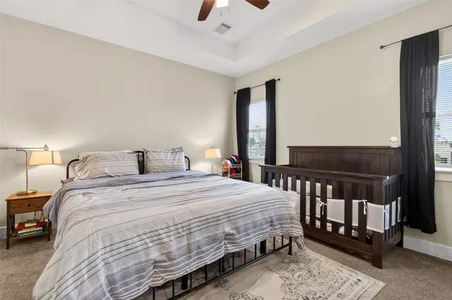 a bedroom with a bed a couch and a chandelier