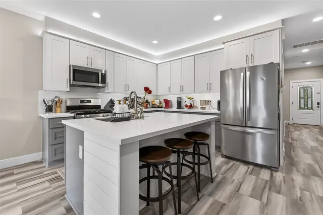 a kitchen with stainless steel appliances a refrigerator stove microwave and cabinets