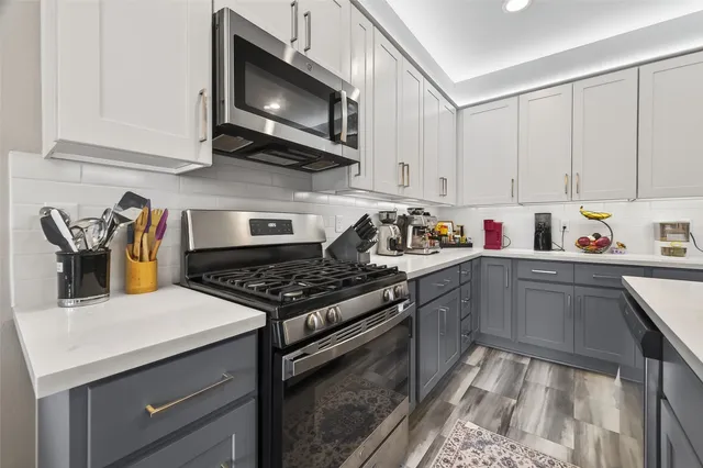 a kitchen with stainless steel appliances granite countertop a stove and a microwave