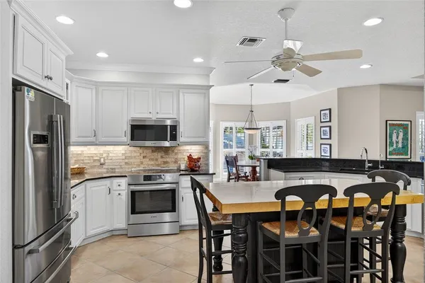 a kitchen with granite countertop white cabinets and stainless steel appliances