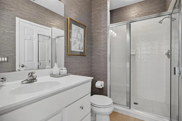 a bathroom with a double vanity sink toilet mirror and shower