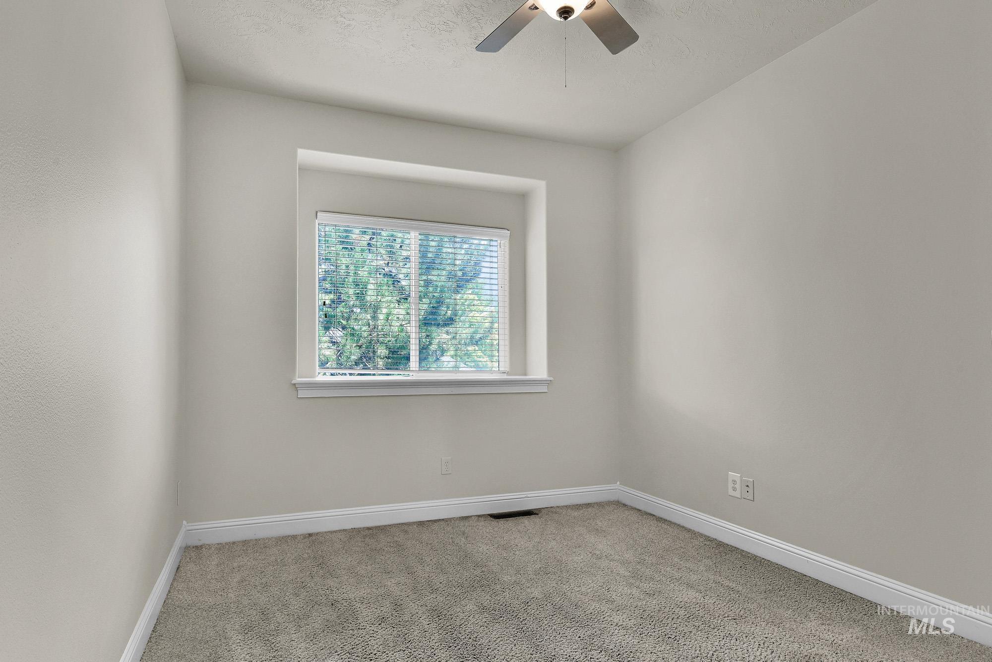 2172 West Cedar Grove Street Meridian, ID 83646 - Photo 28 of 49 Neutral-toned room featuring a single window with white blinds, light gray wall paint, white trim, and gray carpet flooring