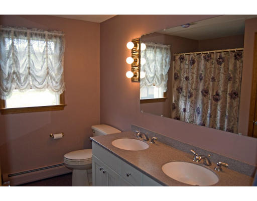111 Strong Road Southampton, MA 01073 - Photo 12 of 20 a bathroom with a granite countertop sink a toilet a mirror and a window