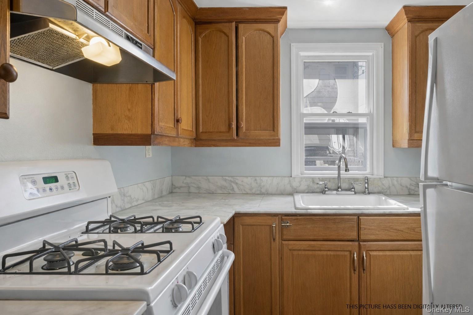 346 Maple Avenue Riverhead, NY 11901 - Photo 4 of 12 a kitchen with a sink stove and cabinets