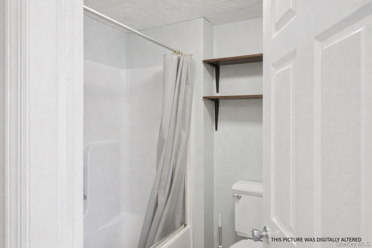 346 Maple Avenue Riverhead, NY 11901 - Photo 9 of 12 a bathroom with a shower and a glass door