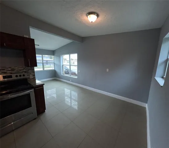 an empty room with windows and fireplace