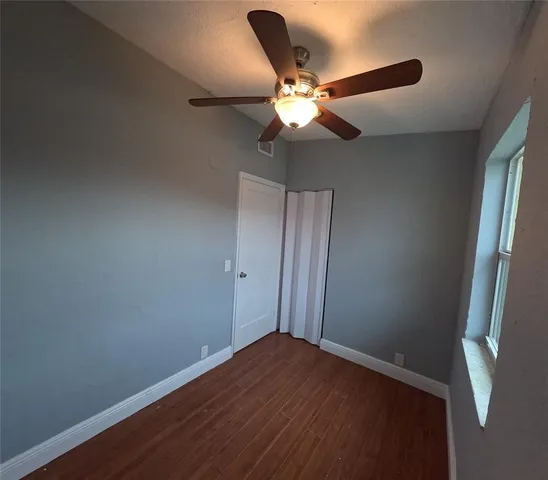a view of empty room with wooden floor