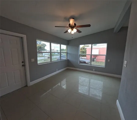 en empty room with windows and ceiling fan