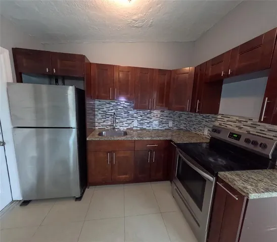 a kitchen with stainless steel appliances granite countertop a refrigerator and a sink