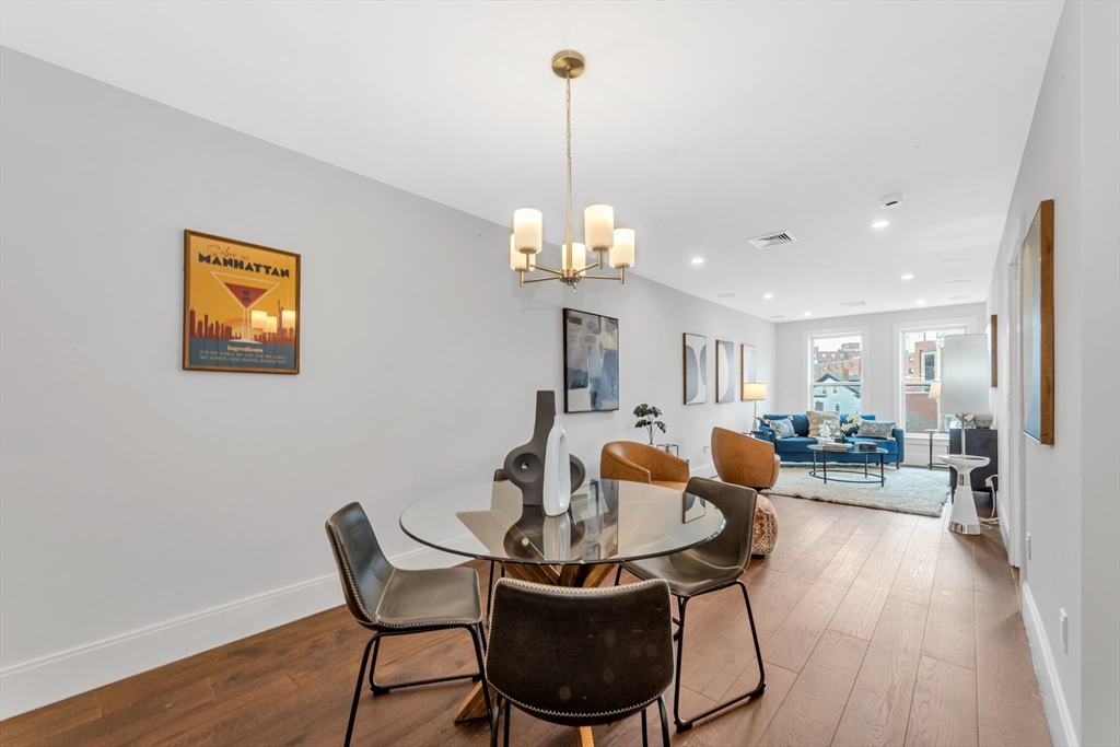 480 West Broadway, Unit 7 Boston, MA 02127 - Photo 5 of 19 a dining room with furniture a chandelier and wooden floor