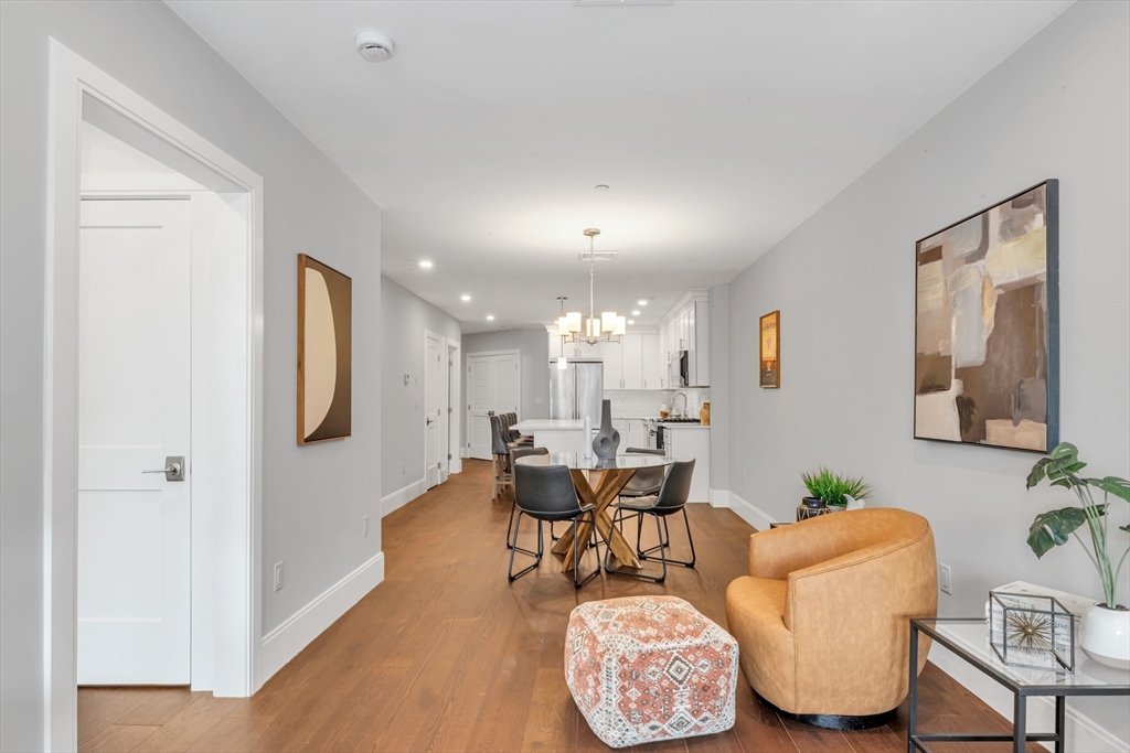 480 West Broadway, Unit 7 Boston, MA 02127 - Photo 7 of 19 a living room with furniture and a chandelier
