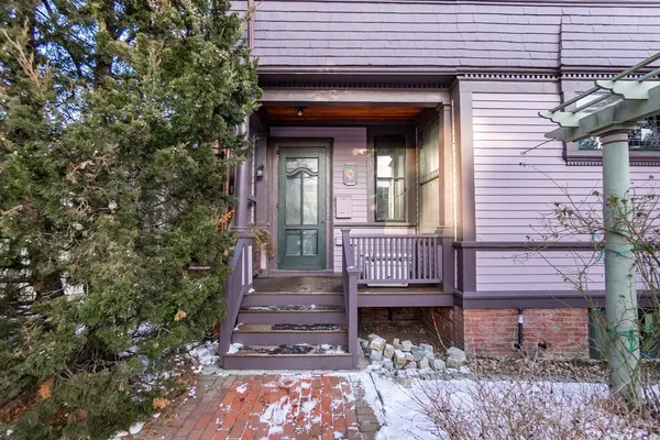 a view of a house with a door and wooden bench