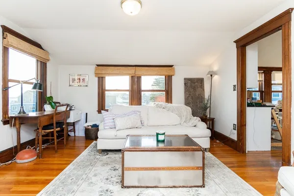 a living room with furniture a table and large windows