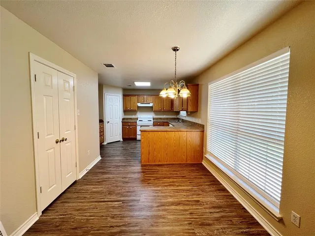 a large kitchen with kitchen island white cabinetry and a chandelier