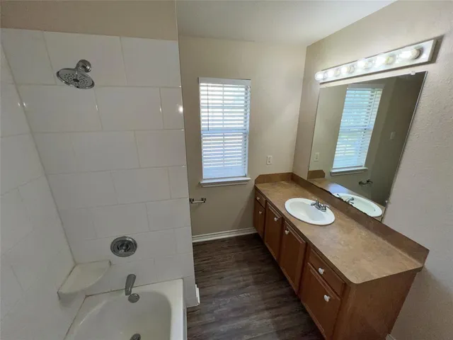 a bathroom with a double vanity sink a mirror and a bathtub