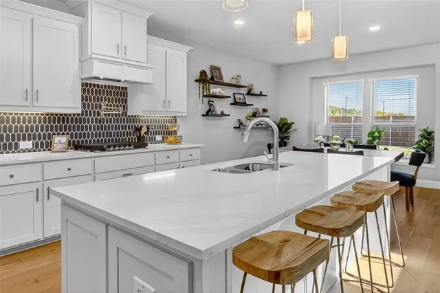 a kitchen with a sink a stove and chairs