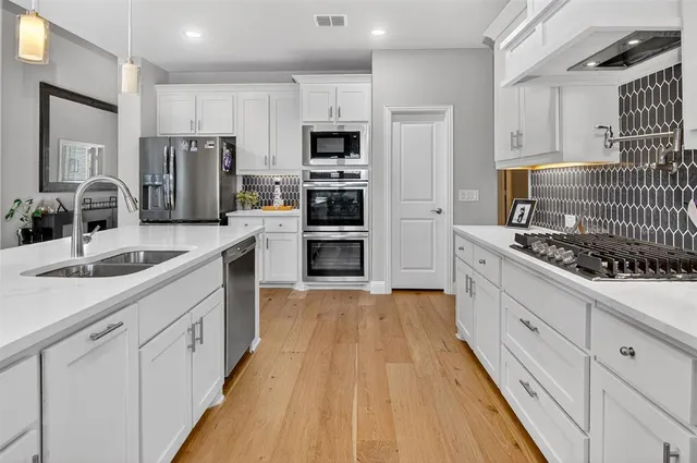 a kitchen with white cabinets and stainless steel appliances