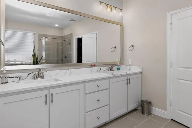 a bathroom with double sink and a mirror