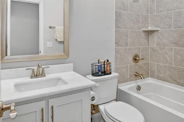 a bathroom with a sink toilet vanity and bathtub