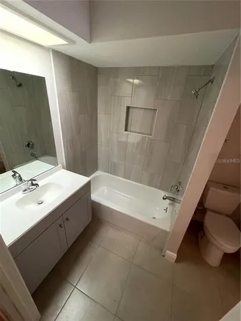 a bathroom with a tub sink and mirror