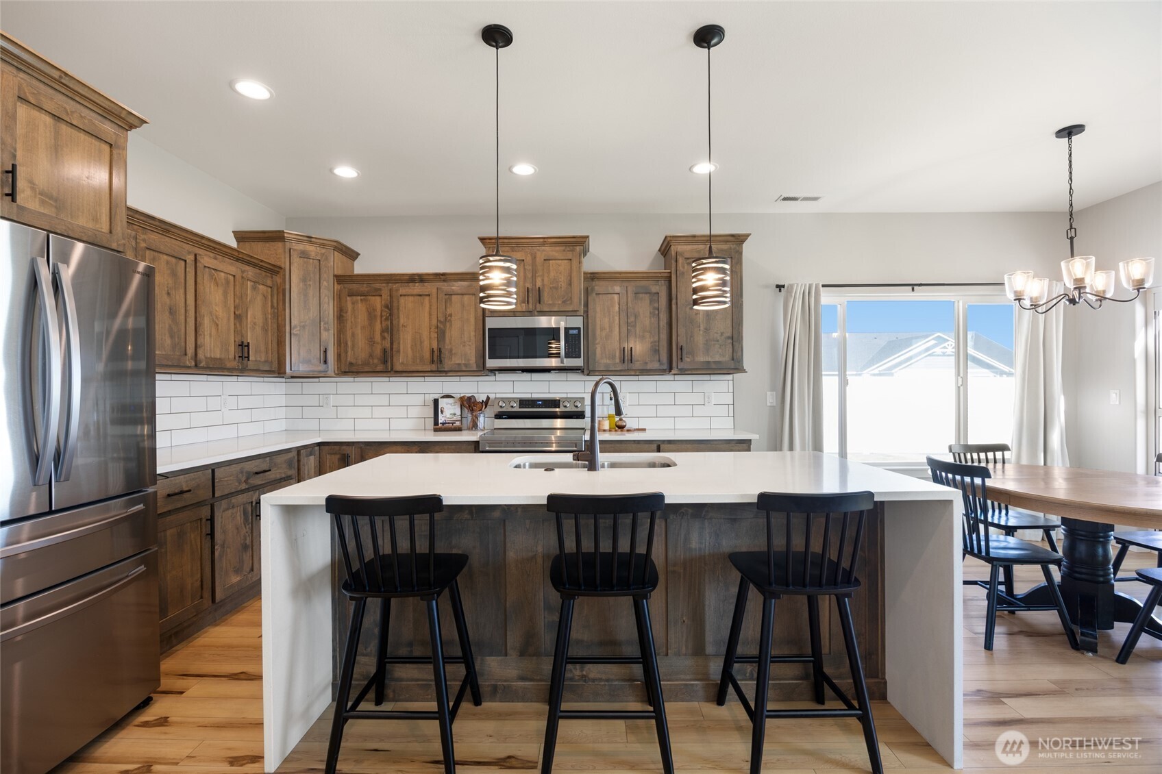 2376 Chelan Street Ephrata, WA 98823 - Photo 14 of 40 a kitchen with stainless steel appliances kitchen island granite countertop a sink a stove a refrigerator and island with wooden floor