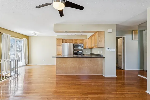 a view of kitchen with stainless steel appliances granite countertop refrigerator stove top oven and cabinets