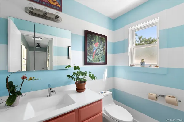 a bathroom with a sink a toilet and mirror