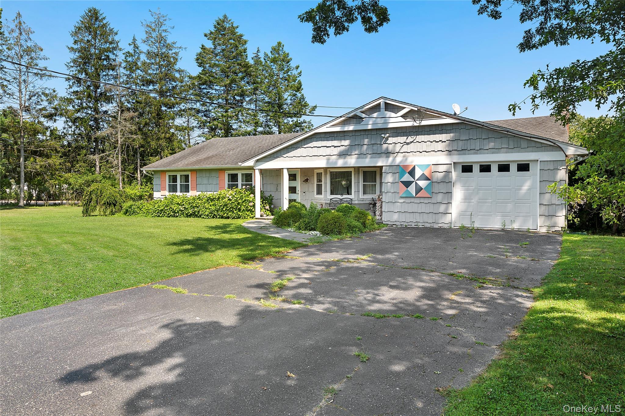 38 Liberty Street Westhampton Beach, NY 11978 - Photo 18 of 23 View of front of property featuring driveway, a garage, a front yard, and a shingled roof