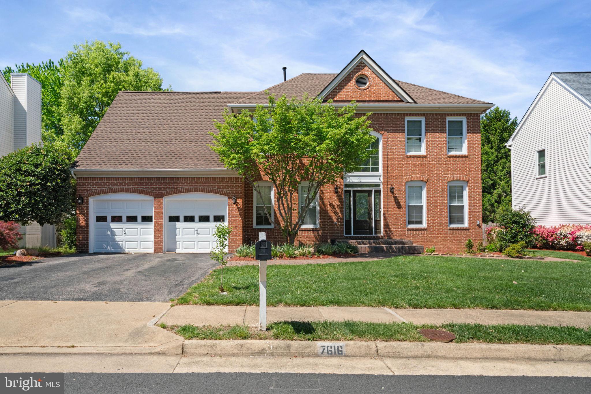 Charming brick home with lush greenery.