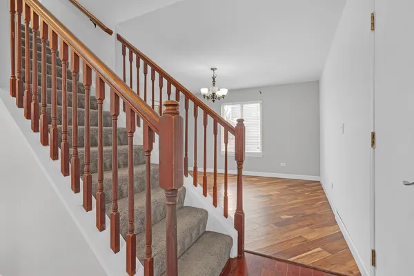 a view of staircase with railing and white walls