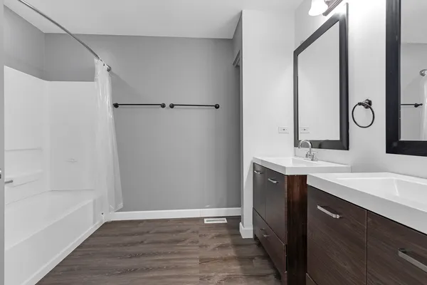 a bathroom with a double vanity sink mirror and shower