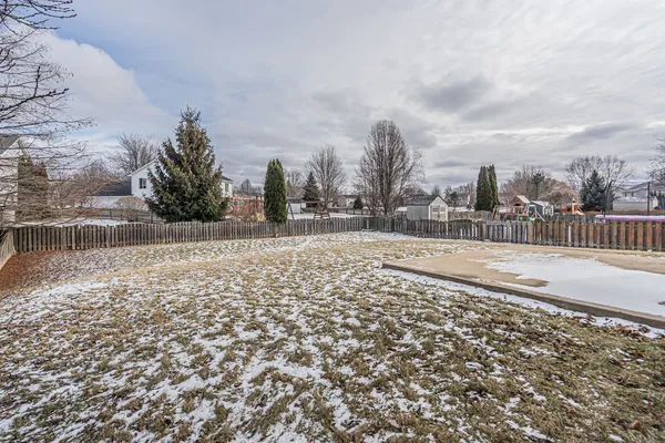 a view of a dry yard with wooden fence