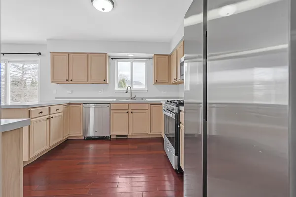 a kitchen with white cabinets stainless steel appliances and a sink