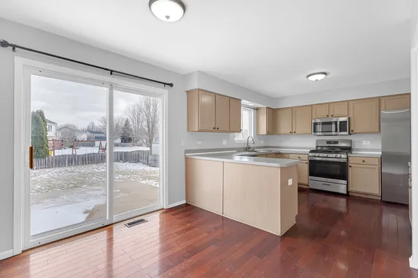 a kitchen with a refrigerator and white cabinets