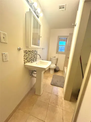 a bathroom with a sink a toilet and mirror