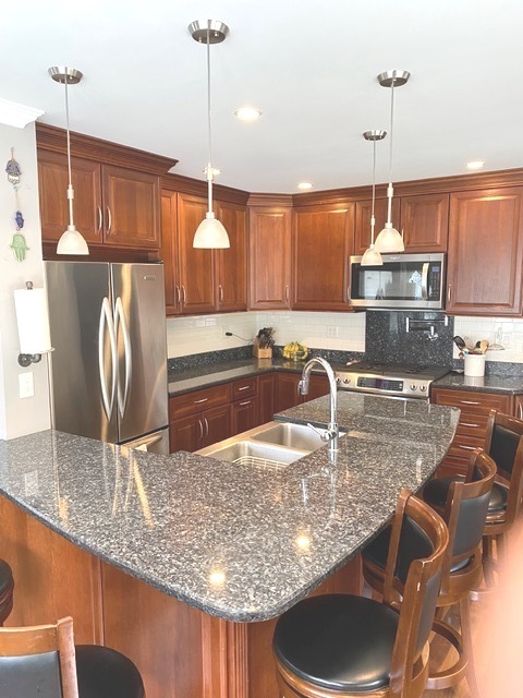 314 Ruth Avenue St. Charles, IL 60174 - Photo 3 of 36 a kitchen with kitchen island granite countertop a sink a counter and chairs