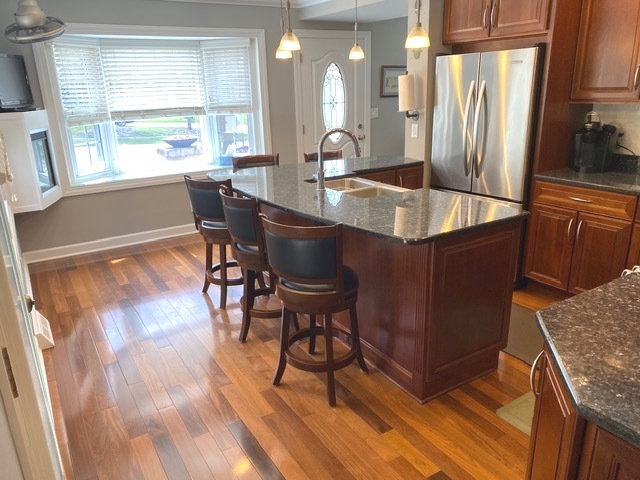 314 Ruth Avenue St. Charles, IL 60174 - Photo 4 of 36 a kitchen with granite countertop a table chairs refrigerator and wooden floor