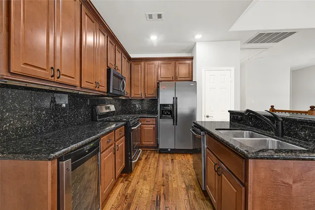 a kitchen with kitchen island granite countertop a sink stove and refrigerator