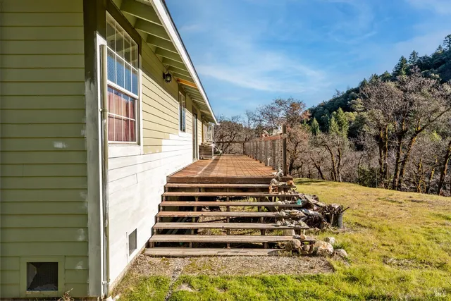 a front view of a house with a yard and large trees