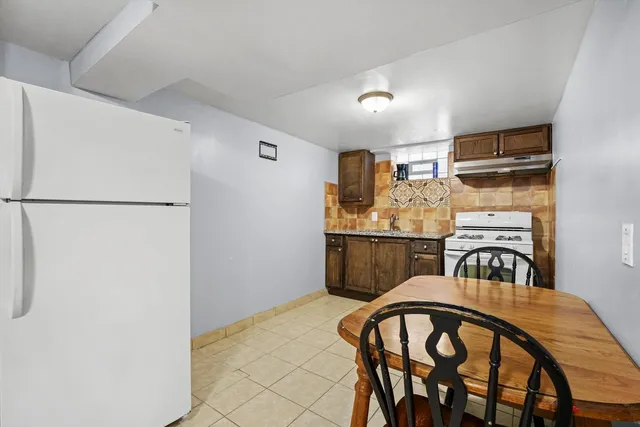 a kitchen with stainless steel appliances a refrigerator a table and chairs