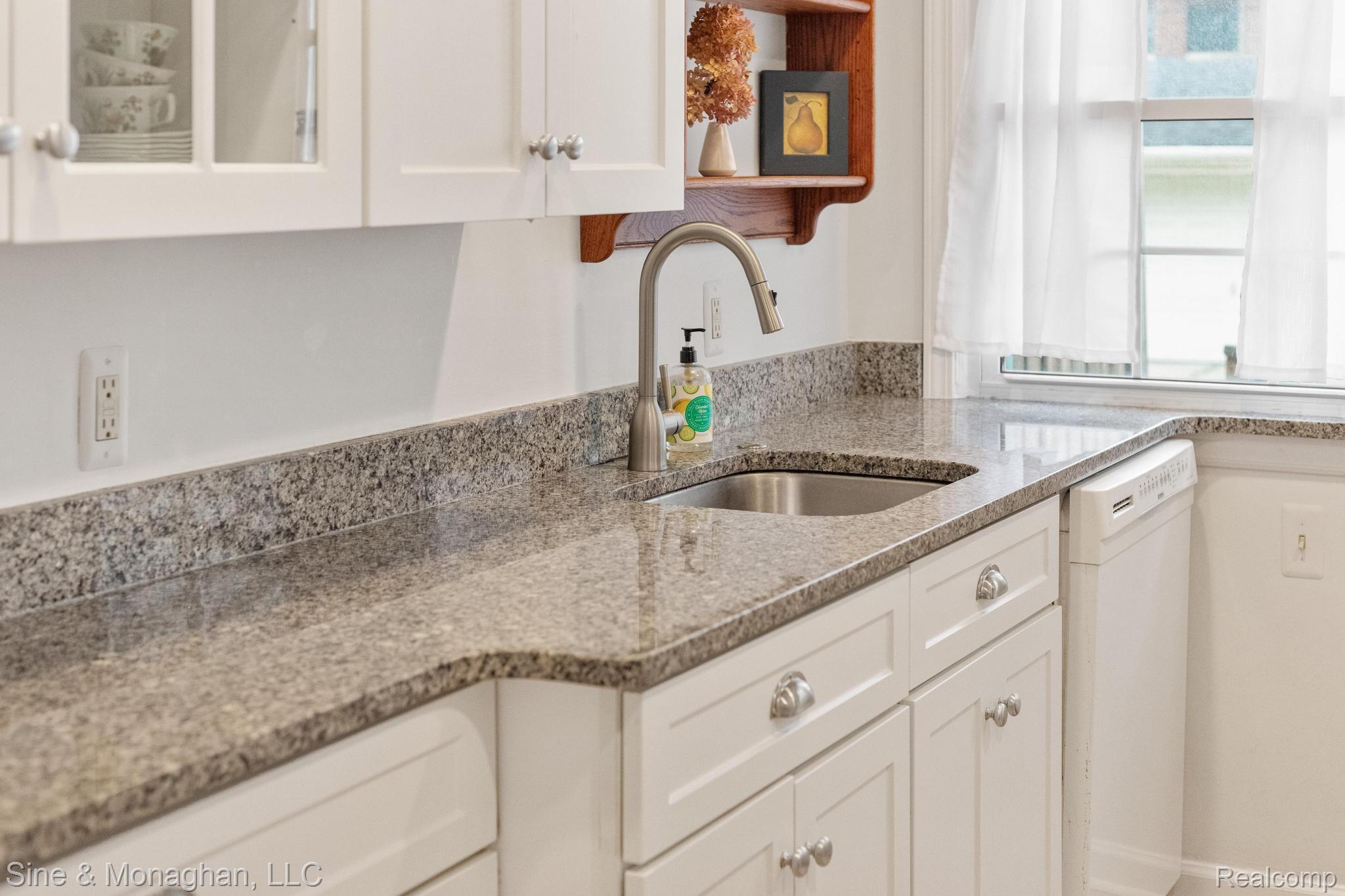 679 Neff Road Grosse Pointe, MI 48230 - Photo 14 of 78 White cabinetry with chrome hardware, speckled countertops, stainless steel sink, and a gooseneck faucet
