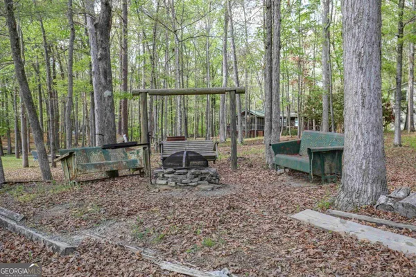 a backyard of a house with large trees and wooden fence